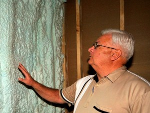 Harrison REMC's Bob Geswein examines the installation of foam insulation. [Photo by Bob Wheeler]