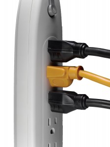 One orange cord and two black cords plugged into a surge protector.